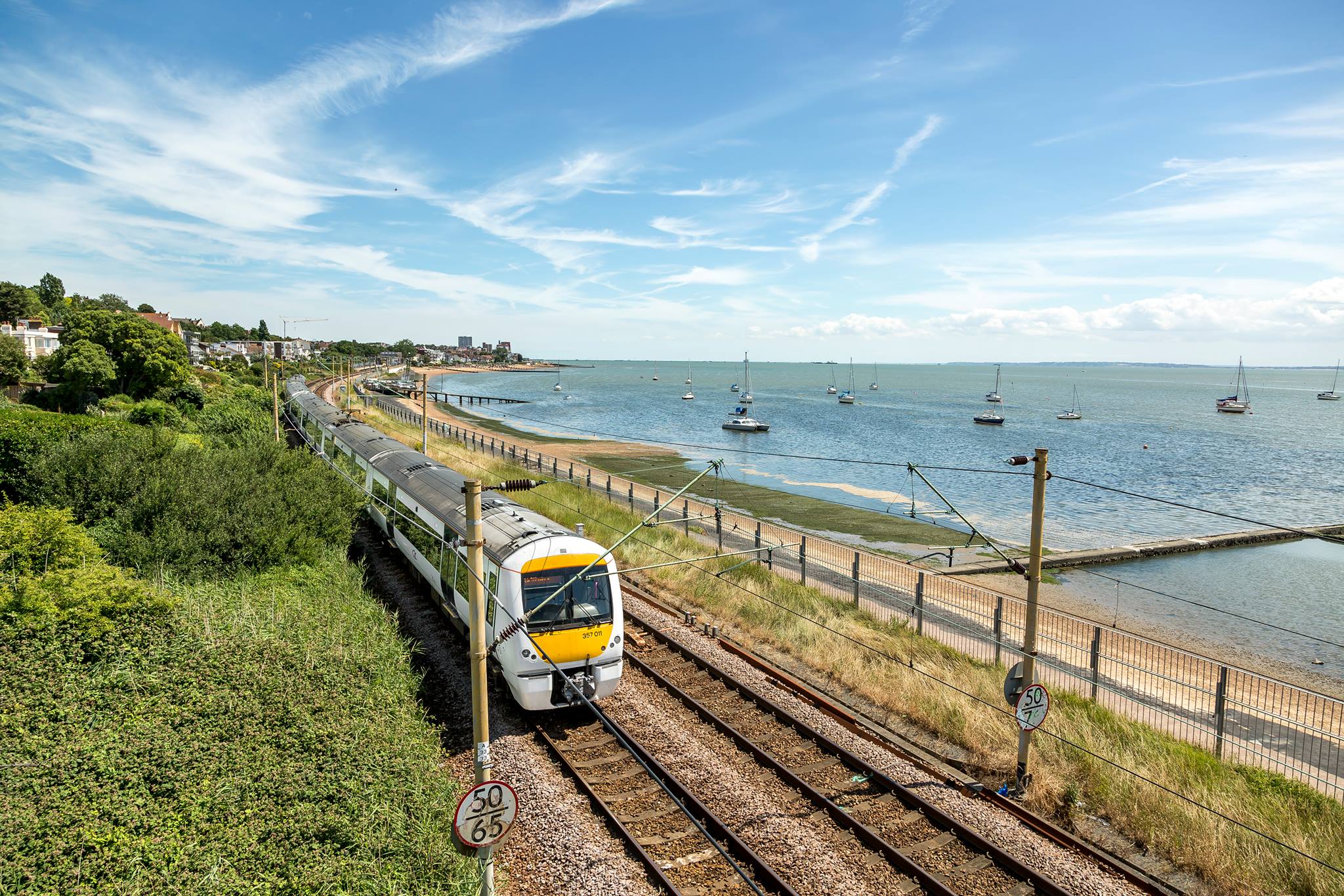 Train travelling on track alongside beach front